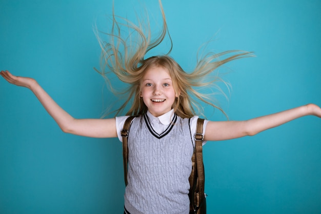 Niña sonriente divertida empujando su cabello hacia arriba y riendo.