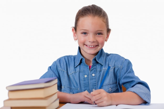 Niña sonriente escribiendo en un cuaderno