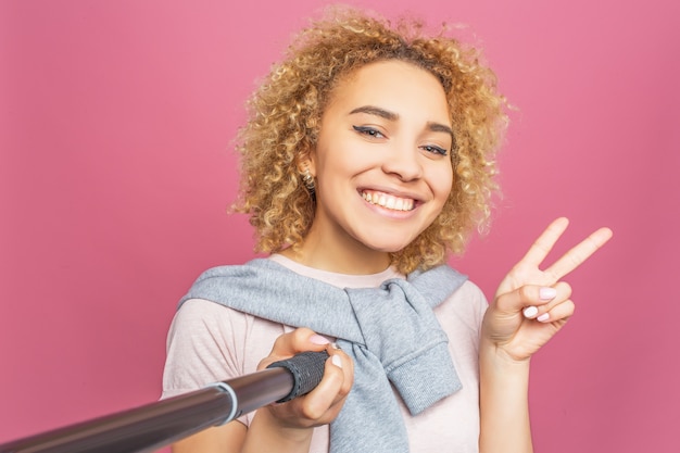 Niña sonriente está tomando una selfie.