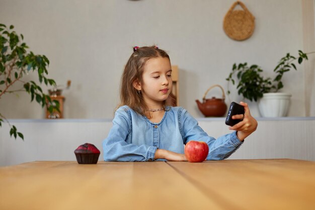 Niña sonriente feliz sosteniendo un teléfono inteligente con una videollamada con un amigo a distancia