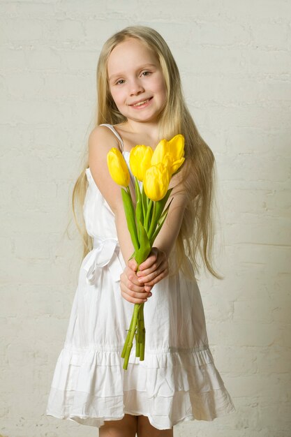 Niña sonriente con flores amarillas