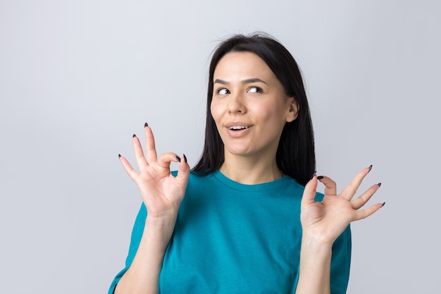 Niña sonriente gesticulando bien firmar con su mano