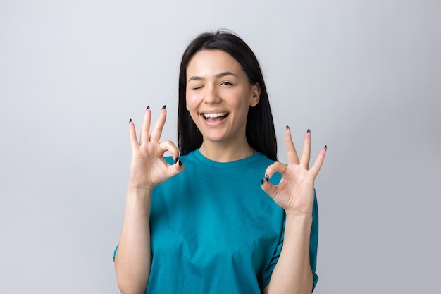 Niña sonriente gesticulando bien firmar con su mano