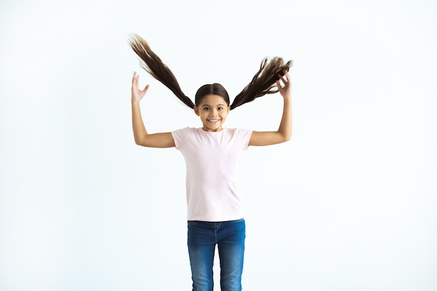 La niña sonriente gesticulando sobre el fondo blanco.