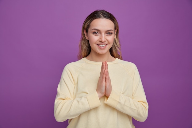 Niña sonriente haciendo gesto de namaste