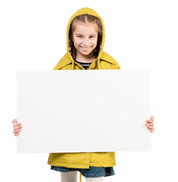 Niña sonriente con la hoja en blanco en las manos