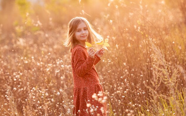 Niña sonriente con hojas de otoño