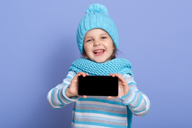 Niña sonriente niño vestidos moderno sombrero de invierno