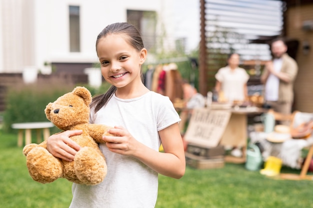 Niña sonriente con oso de juguete