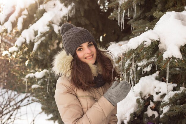 Niña sonriente en el parque en invierno con mucha nieve alrededor