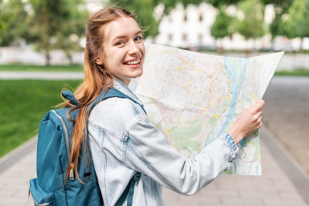 Foto niña sonriente en el parque usando un mapa