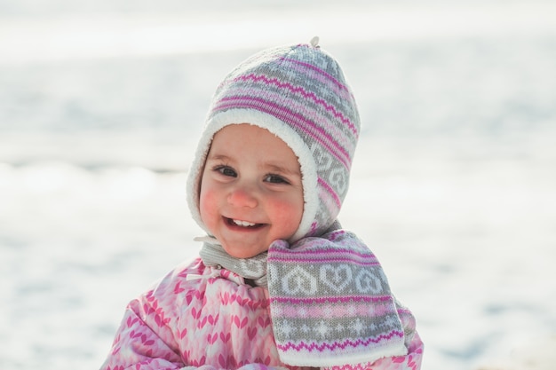 Niña sonriente la primera vez en tu vida caminando sobre la nieve