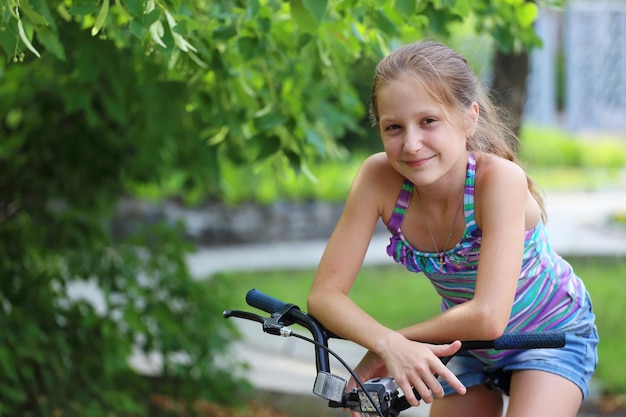 Niña sonriente sentada en una bicicleta