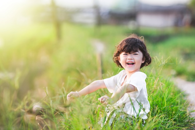 Niña sonriente sentada en el césped