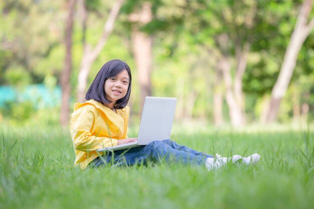 Niña sonriente sentada en el césped