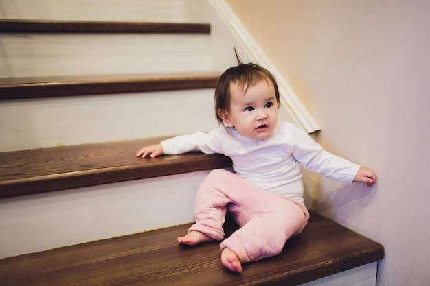 Niña sonriente sentada en las escaleras.