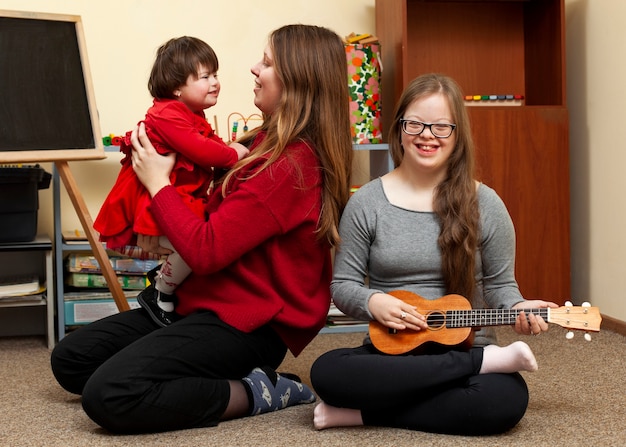 Niña sonriente con síndrome de down y mujer con niño