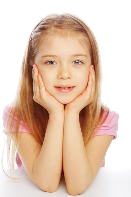 Niña sonriente sobre fondo blanco en estudio