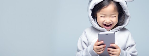 Foto niña sonriente con un teléfono celular en un fondo de color
