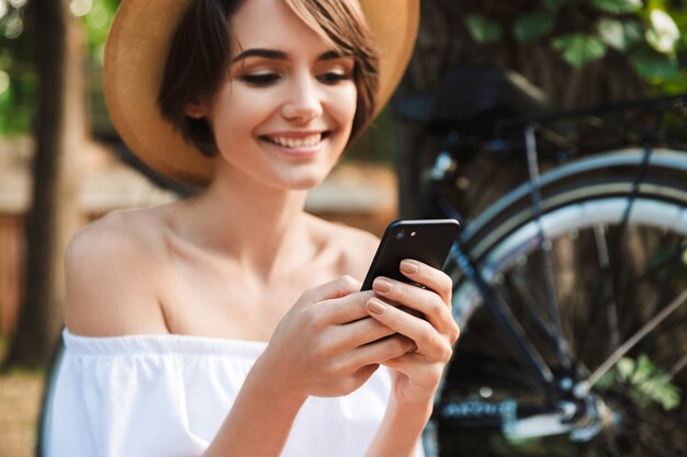 Niña sonriente mediante teléfono móvil