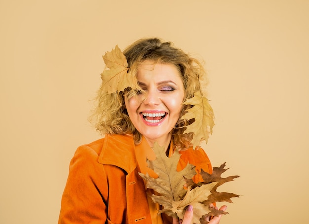 Foto niña sonriente con tendencias de la moda de la hoja de otoño para la caída de la hoja de otoño otoño mujer con dorado