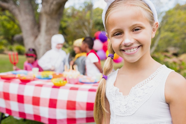 Niña sonriente vistiendo un traje durante una fiesta de cumpleaños