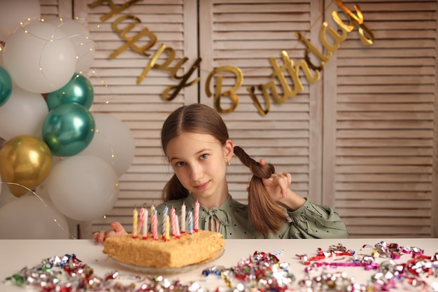 Una niña sopla las velas de un pastel de cumpleaños