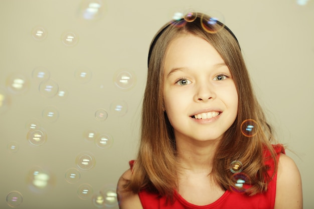 niña soplando pompas de jabón