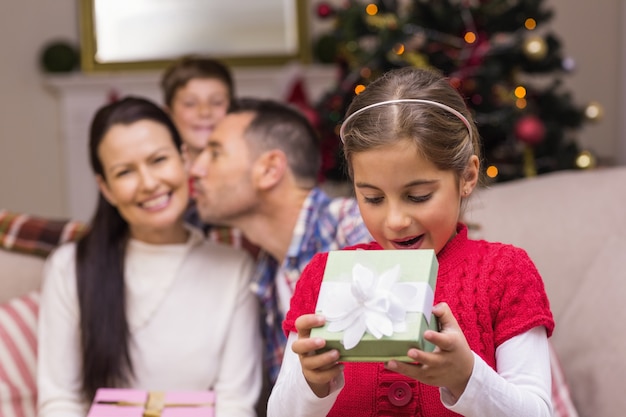 Niña sorprendida abriendo un regalo