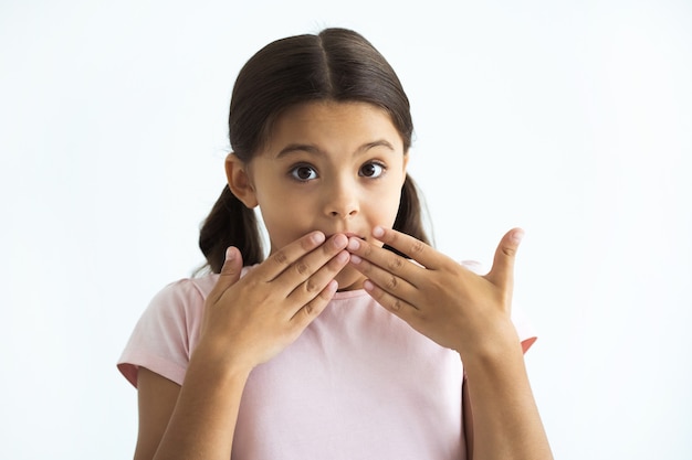 La niña sorprendida de pie sobre el fondo blanco.