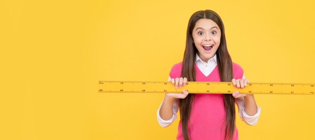 Niña sorprendida usa regla para aprender medidas matemáticas Banner de estudiante de escuela Retrato de alumno de colegiala con espacio de copia