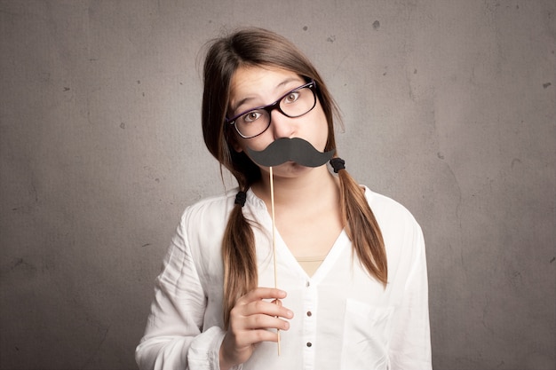 Niña sosteniendo un bigote