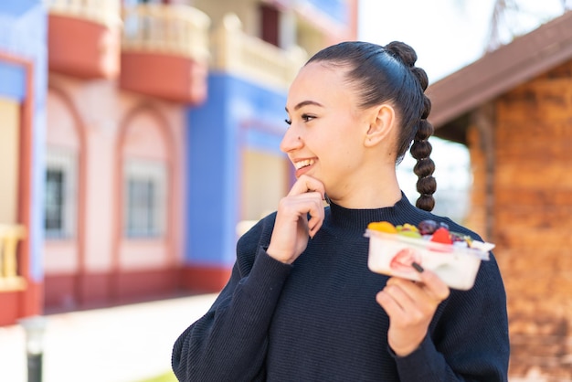 niña sosteniendo una caja de frutas