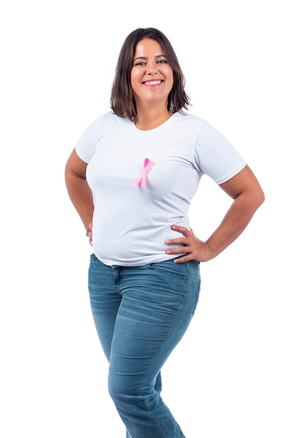 niña sosteniendo la cinta del cáncer de mama sobre un fondo blanco sonriendo.