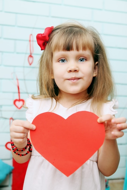 Niña sosteniendo un corazón en las manos