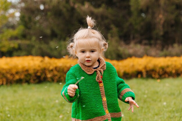 Niña sosteniendo un diente de león en sus manos.