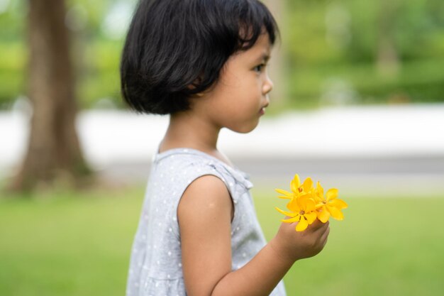 Una niña sosteniendo una flor en sus manos