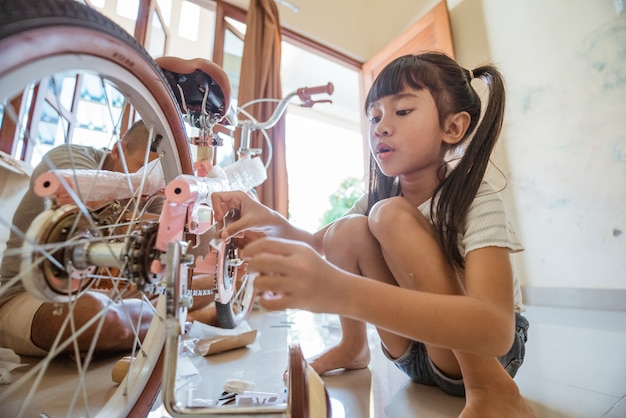 Niña sosteniendo una herramienta para apretar tornillos