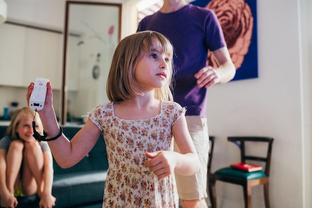 Niña sosteniendo un joystick jugando videojuegos en casa