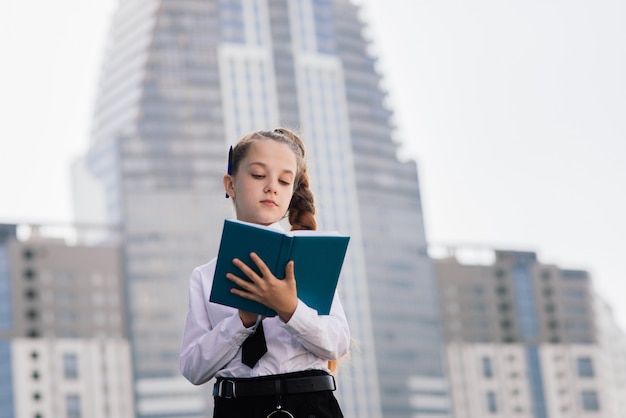 Niña sosteniendo un libro en la ciudad