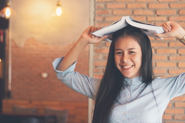 niña sosteniendo libro posando con diversión y feliz.