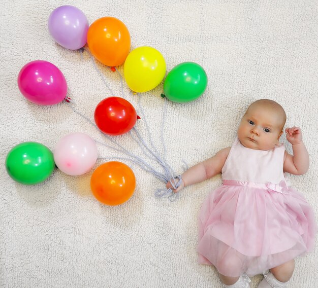 Niña sosteniendo un montón de globos y espectáculos de vuelo