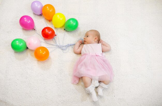 Niña sosteniendo un montón de globos y espectáculos de vuelo