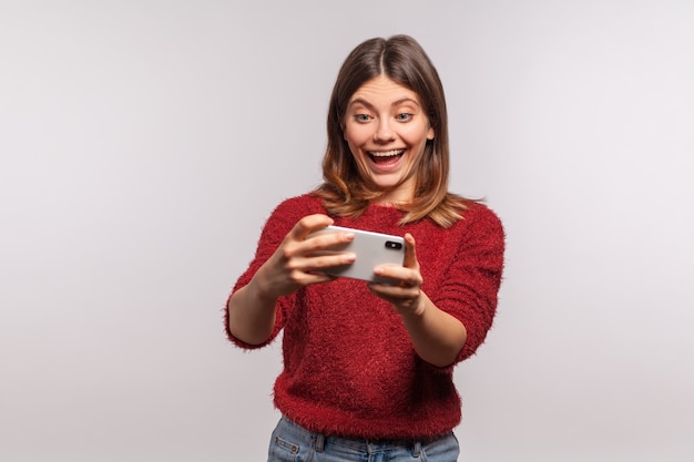 niña sosteniendo el móvil y jugando en el teléfono