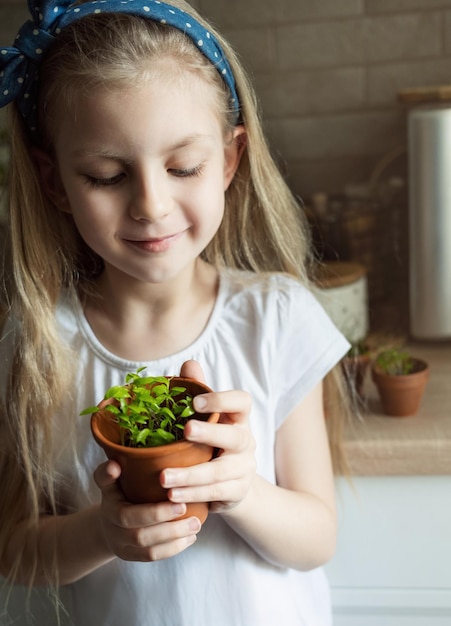 Niña sosteniendo una olla de plántulas