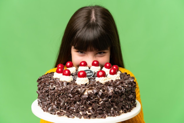 Niña sosteniendo pastel de cumpleaños sobre fondo clave de croma aislado