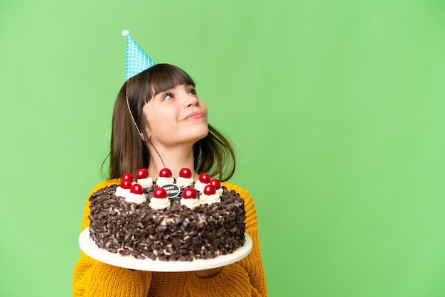 Niña sosteniendo pastel de cumpleaños sobre fondo clave de croma aislado