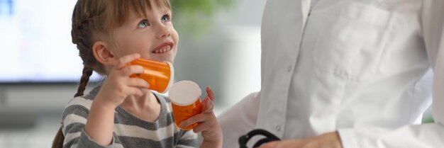 Niña sosteniendo pastillas en cita con el pediatra