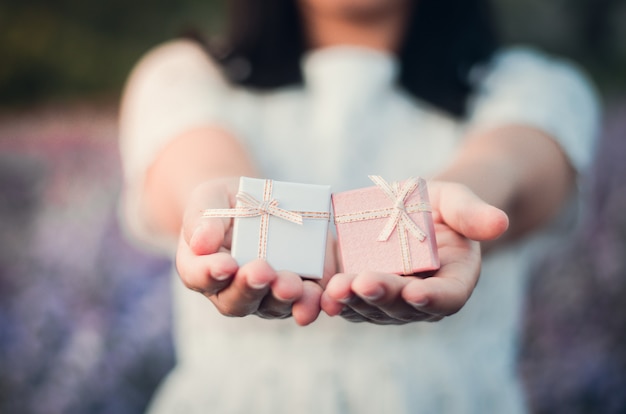 Foto niña sosteniendo pequeñas cajas de regalo