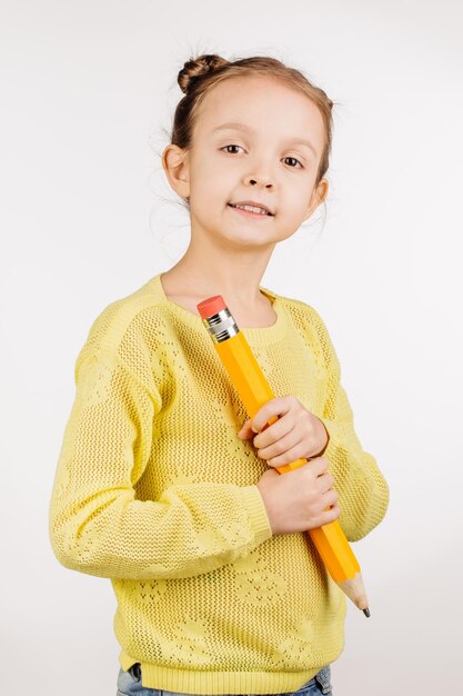 Niña sosteniendo una pluma enorme